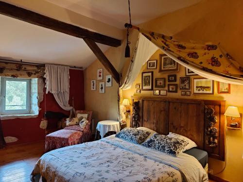 une chambre avec un lit et des tableaux au mur dans l'établissement Guest House Château le But proche de Périgueux en Dordogne, à Léguillac-de-Lauche