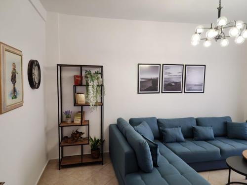 uma sala de estar com um sofá azul num quarto em Durres Center em Durrës
