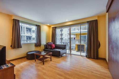 a living room with a couch and a table at Elite Suites Patong in Patong Beach