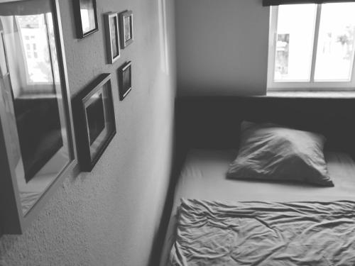 1 dormitorio con cama, ventana y almohada en Die Praxis - Wohnen als Therapie, en Arnstadt