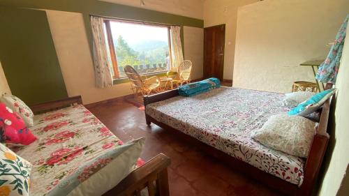 a bedroom with two beds and a window at Thendral: Delightful homestay on a hill near Ooty in Naduvattam