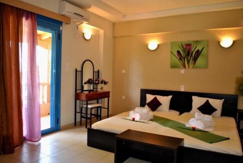 ミティカスにあるIliovasilema Hotelのベッドルーム1室(ベッド1台、テーブル、窓付)
