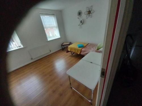 uma sala de estar com um sofá e uma mesa em Private rooms, 2 showers in 3 storey hse, 25 minutes walk from Leicester city centre em Leicester