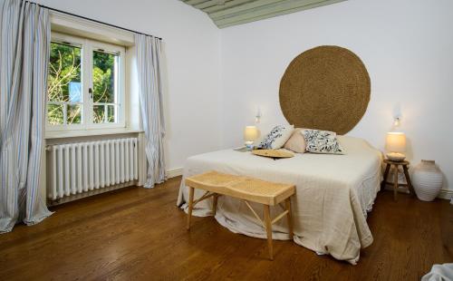 una camera bianca con un letto e una finestra di Elegant Brac Villa 4 Bedrooms Villa Beachfront Oasis Stunning Sea Views and Walking Distance to Beach Murvica a Murvica