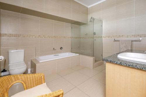 een badkamer met een bad, een toilet en een wastafel bij Owls Loft Guesthouse in Johannesburg