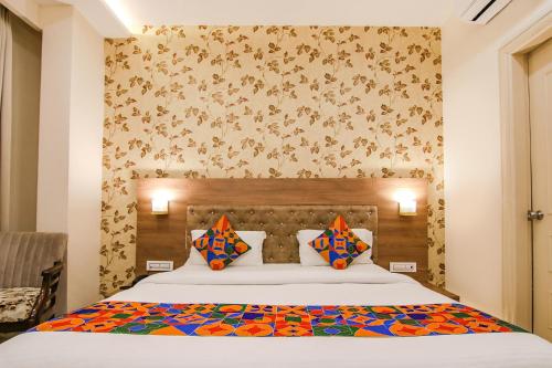 a bedroom with a large bed with colorful pillows at Hotel Florida -Manali Highway & 9 mins drive from Chandigarh University in Kharar