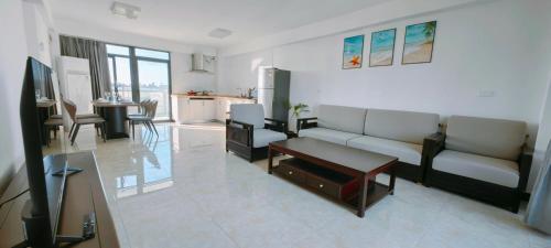 a living room with a couch and a table and a kitchen at Ocean Breeze Apartment in Nadi