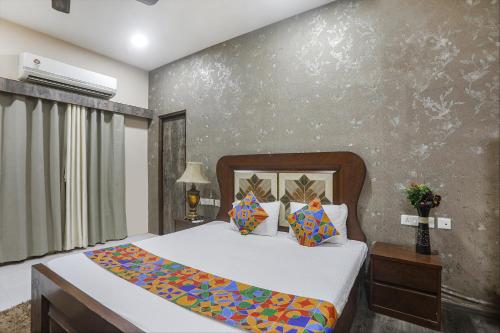 1 dormitorio con cama y pared en FabHotel Classic Stay Inn, en Nagpur