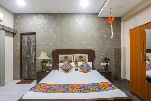 1 dormitorio con 1 cama y una pared con flores en FabHotel Classic Stay Inn, en Nagpur