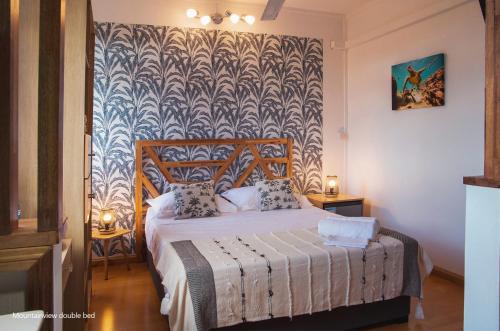 a bedroom with a bed with a patterned wall at Casa Maria in Port Louis