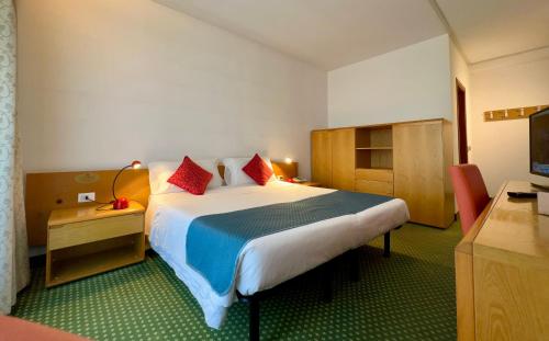 a hotel room with a large bed and a television at Hotel Bella Venezia in Latisana