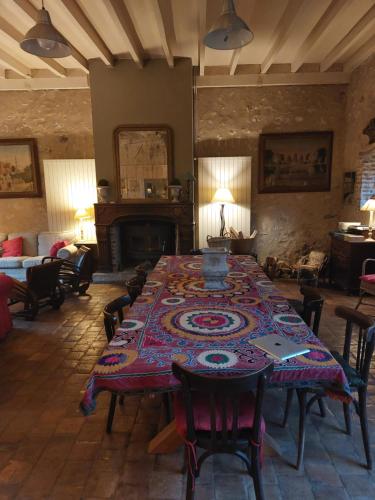a large room with a table and a fireplace at Le Foulon - Moulin de Charme - 1 heure 30 de Paris in Saint-Hilaire-les-Andrésis