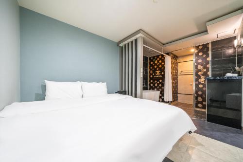 a bedroom with a white bed and a wine cellar at MU HOTEL in Busan