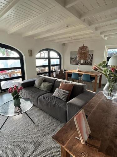 a living room with a couch and a table at Have a nice stay! - Vakantiehuis BijSaar in Noordwijk