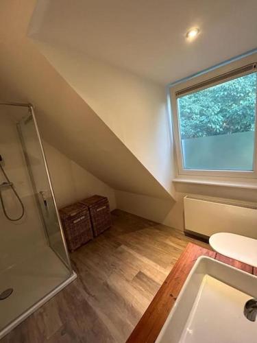 a bathroom with a shower and a sink and a window at Have a nice stay! - Vakantiehuis BijSaar in Noordwijk