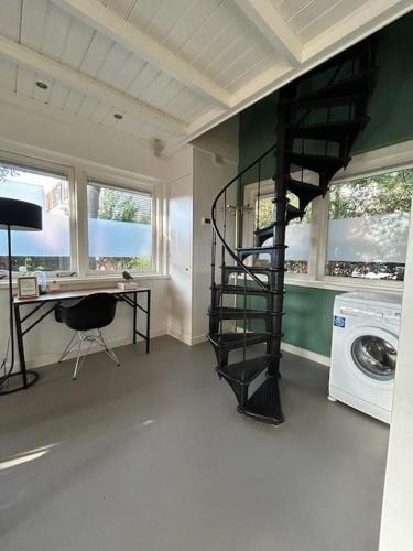 a living room with a spiral staircase in a house at Have a nice stay! - Vakantiehuis BijSaar in Noordwijk