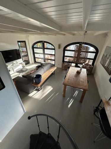 a view of a living room with a couch and a table at Have a nice stay! - Vakantiehuis BijSaar in Noordwijk