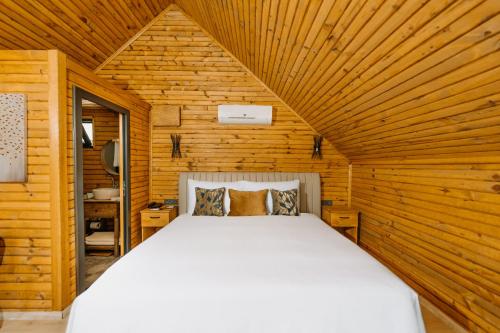 a bedroom with a bed in a wooden cabin at Doors Urla Hotel & Bungalows in İzmir