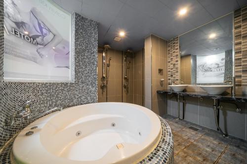 釜山的住宿－MU HOTEL，一间带大浴缸和两个盥洗盆的浴室