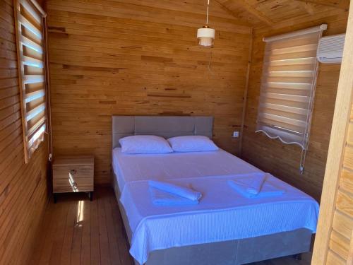 1 dormitorio con 1 cama en una habitación de madera en Assos Green Bungalow, en Ayvacık