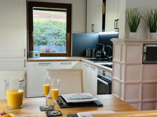 a kitchen with a table with two glasses of orange juice at Ferienhaus Ella in Trautskirchen
