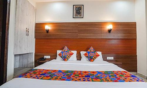 a bedroom with a large bed with a wooden headboard at FabHotel Grace Inn in Gurgaon