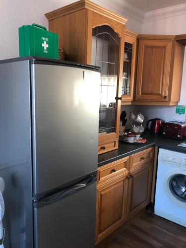 a kitchen with a refrigerator with a green box on top at F2 STUDIO - 485sq Feet 4 Room - PERFECT for LONG STAY - FREE STREET PARKING - WASHER - NETFLIX - Welcome Tray 1 FREE Dog in Barry