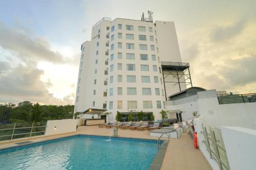 a building with a swimming pool in front of a building at Gokulam Grand Trivandrum in Trivandrum