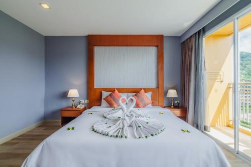 a bedroom with a large bed with a large window at Elite Suites Patong in Patong Beach