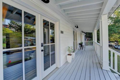 a white house with a porch with glass doors at Modern Farm house in heart of the City- Sleeps 12 in Atlanta