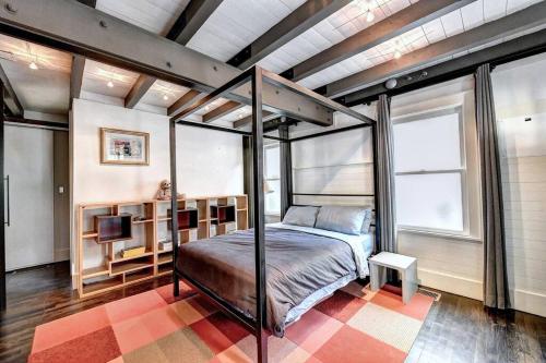 a bedroom with a canopy bed in a room with windows at Modern Farm house in heart of the City- Sleeps 8 in Atlanta