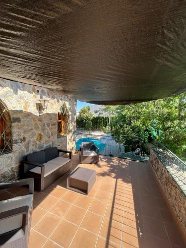 a patio with couches and a stone wall at Casa Rural La Moraleja in Villanueva del Arzobispo