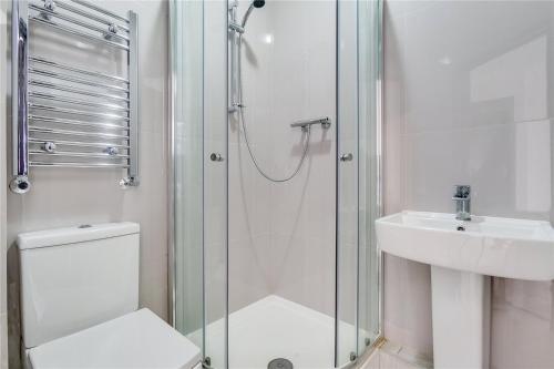 a bathroom with a shower and a toilet and a sink at Luxury Boutique Studio London in London
