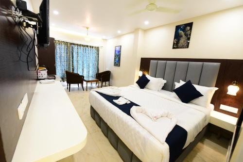 ein Hotelzimmer mit einem großen Bett und einem Tisch in der Unterkunft Puri Beach Resort in Puri