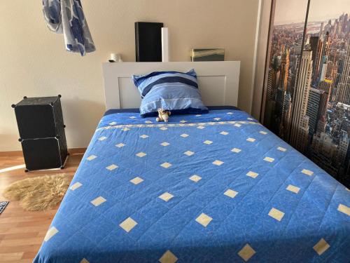 Schlafzimmer mit einem Bett mit blauer Decke in der Unterkunft 68 in Berlin