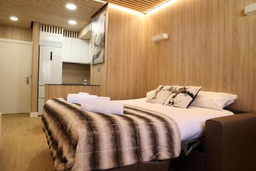 een slaapkamer met een groot bed met een deken erop bij Apartamento Hartza in Vielha