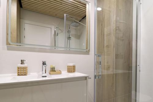 bagno con lavandino, specchio e doccia di Apartamento Hartza a Vielha