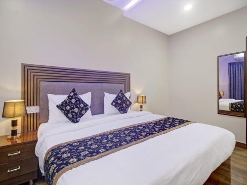 a bedroom with a large white bed with blue pillows at THE SUPERB HOTEL PVT LTD in Hyderabad