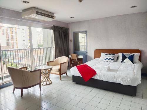 1 dormitorio con 1 cama, mesa y sillas en OYO 75446 Travis Inthamara 49 en Bangkok