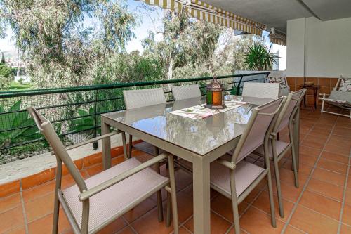 comedor con mesa y sillas en el balcón en Guadavillas 320, en Marbella