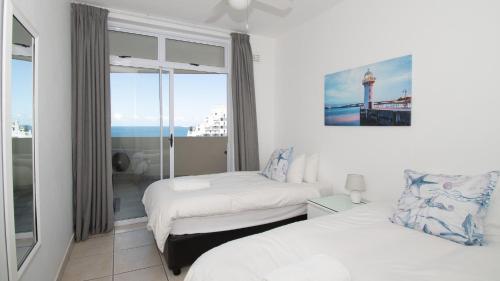 a hotel room with two beds and a window at 72 Sea Lodge Umhlanga Rocks in Durban