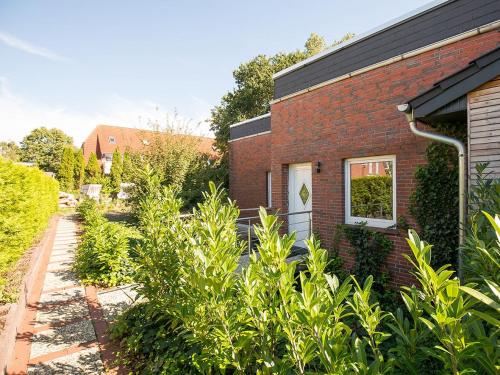 un jardín frente a un edificio de ladrillo en Ferienwohnung Jonte, FeWo Vermittlung Nordsee, en Dangast