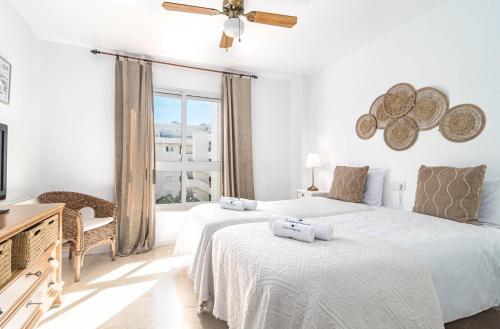 2 camas en una habitación blanca con ventana en Guadavillas 320, en Marbella