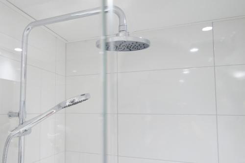 a shower with a glass door and a shower head at Home Hotel Drott in Karlstad