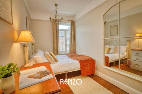 a bedroom with a bed and a mirror at Spacious 3-bed Home in Lincoln by Renzo, Stunning Design, Close to Lincoln Cathedral! in Lincolnshire