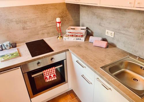 uma cozinha com fogão forno ao lado de um lavatório em Fleckalm Chalets em Kirchberg in Tirol