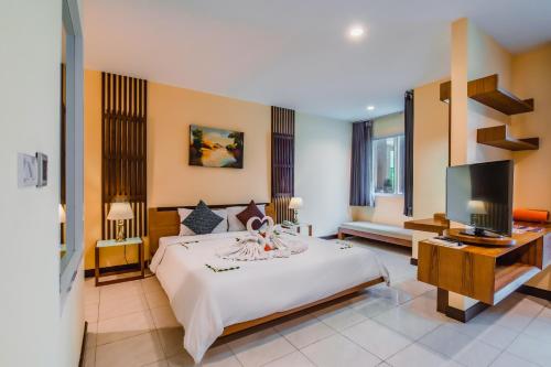a bedroom with a bed and a flat screen tv at Elite Suites Patong in Patong Beach