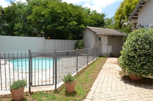 une clôture en face d'une piscine dans l'établissement Lonehill - Standard 2 Guest Studio Suite 2, à Sandton