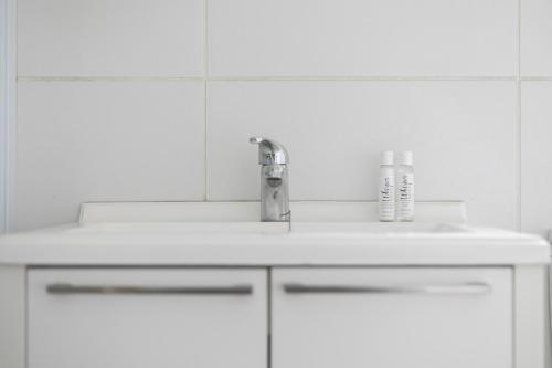 W białej łazience znajduje się umywalka i lustro. w obiekcie K Luxe Apartment w mieście Sandton
