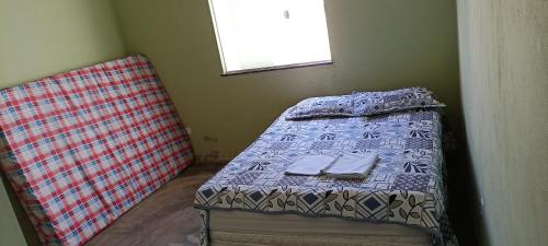 a small bedroom with a bed and a window at Casa de praia giovani in Aracaju